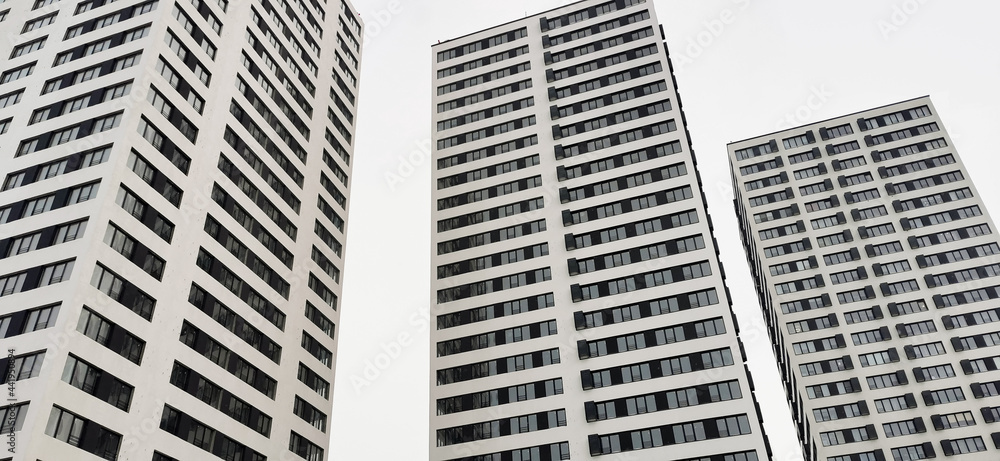 Architectural Construction concept. Advertising. Three identical, new buildings, skyscrapers, residential black and white houses on white background. shot from below, bottom view. Rhythm, reiteration