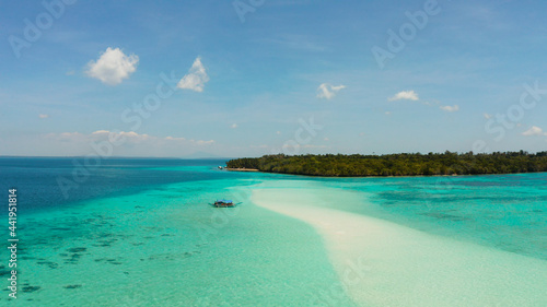 Sand bar and tropical island in the clear turquoise waters of the lagoon and atoll with a coral reef. Mansalangan sandbar, Balabac, Palawan, Philippines. Summer and travel vacation concept