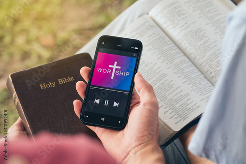 Fotografie Christian friends group reading and study bible from mobile phones praying worship to GOD with church online Sunday in the garden at