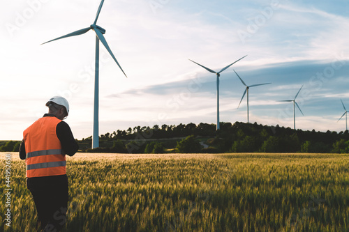 Engineer working at alternative renewable wind energy farm - Sustainable energy industry concept photo