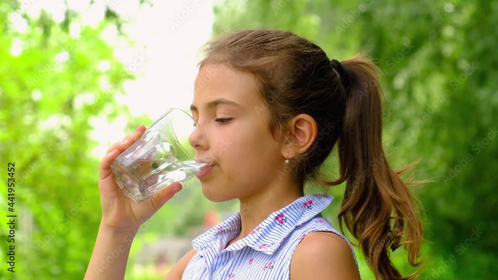 Child girl drinks water from a glass. Selective focus. Child girl drinks water from a glass. Selective focus.
