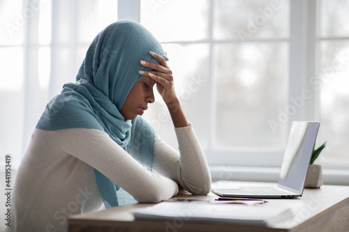 Working Stress. Upset Black Woman In Hijab Sitting At Desk With Laptop © Prostock-studio