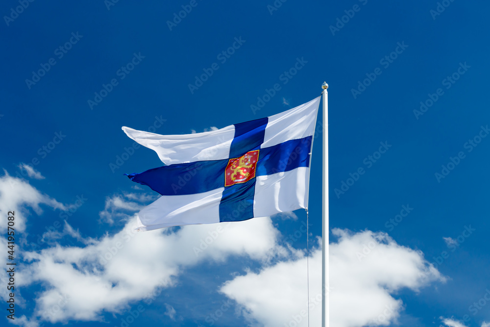 State flag of Finland with national coat of arms against blue sky on the wind State flag of Finland with national coat of arms against blue sky on the wind