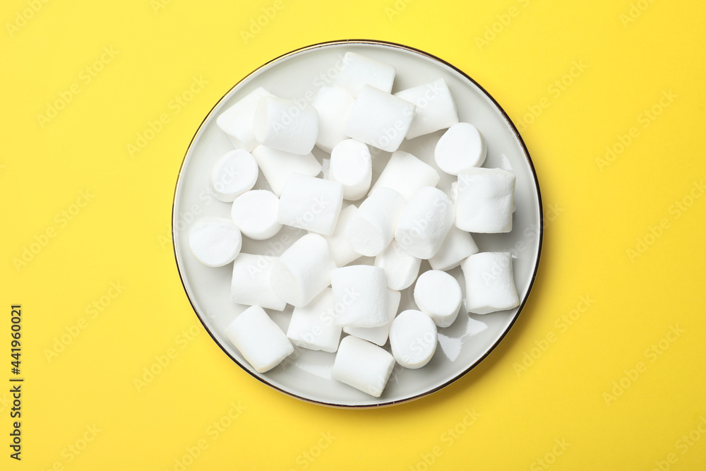 Delicious puffy marshmallows on yellow background, top view Delicious puffy marshmallows on yellow background, top view