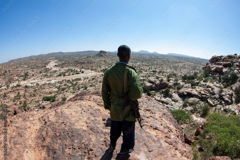 Back view of a Somaliland police force overlooking the wilderness from the top of the hill