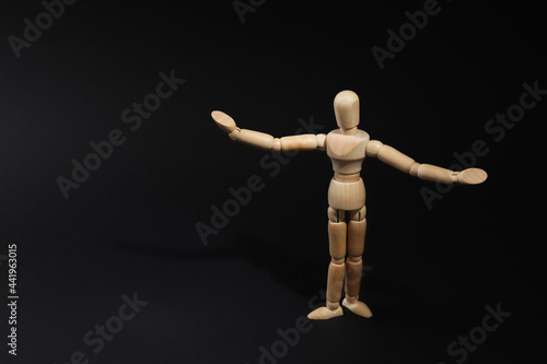 Wooden human model on black background, space for text. Mini mannequin