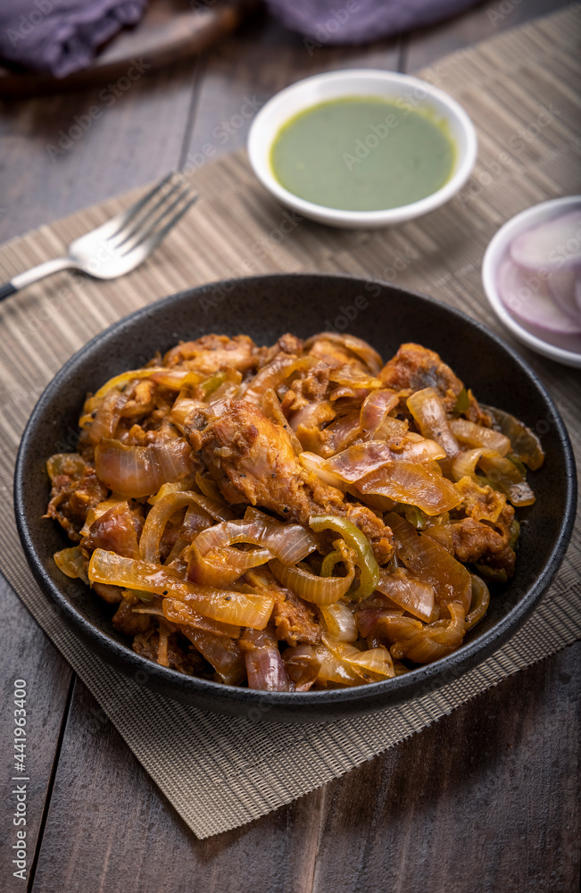 Chilli chicken is a popular Indo-Chinese dish, served on a plate on wooden background
Chilli chicken is a popular Indo-Chinese dish, served on a plate on wooden background
