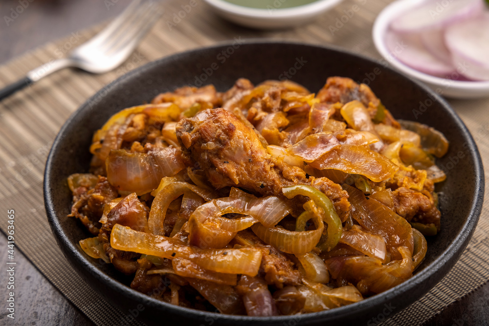 Chilli chicken is a popular Indo-Chinese dish, served on a plate on wooden background
Chilli chicken is a popular Indo-Chinese dish, served on a plate on wooden background