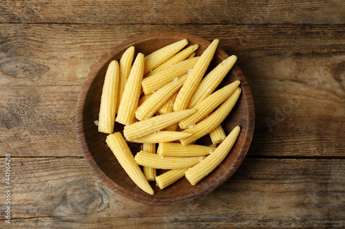 Fresh baby corn cobs on wooden table, top view