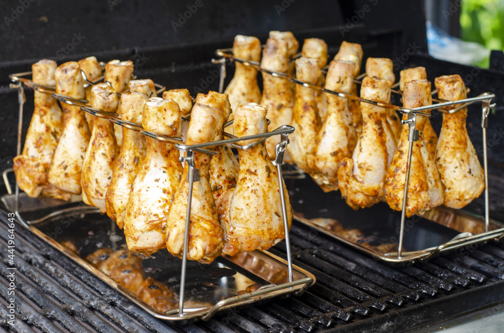 grilled chicken wings on the grill, golden chicken drumsticks close up, grilling in a grill stand grilled chicken wings on the grill, golden chicken drumsticks close up, grilling in a grill stand