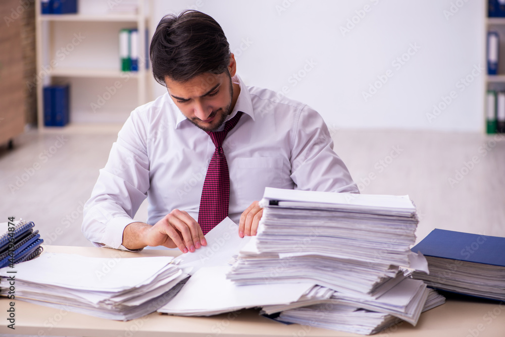 Young businessman employee unhappy with excessive work in the office
