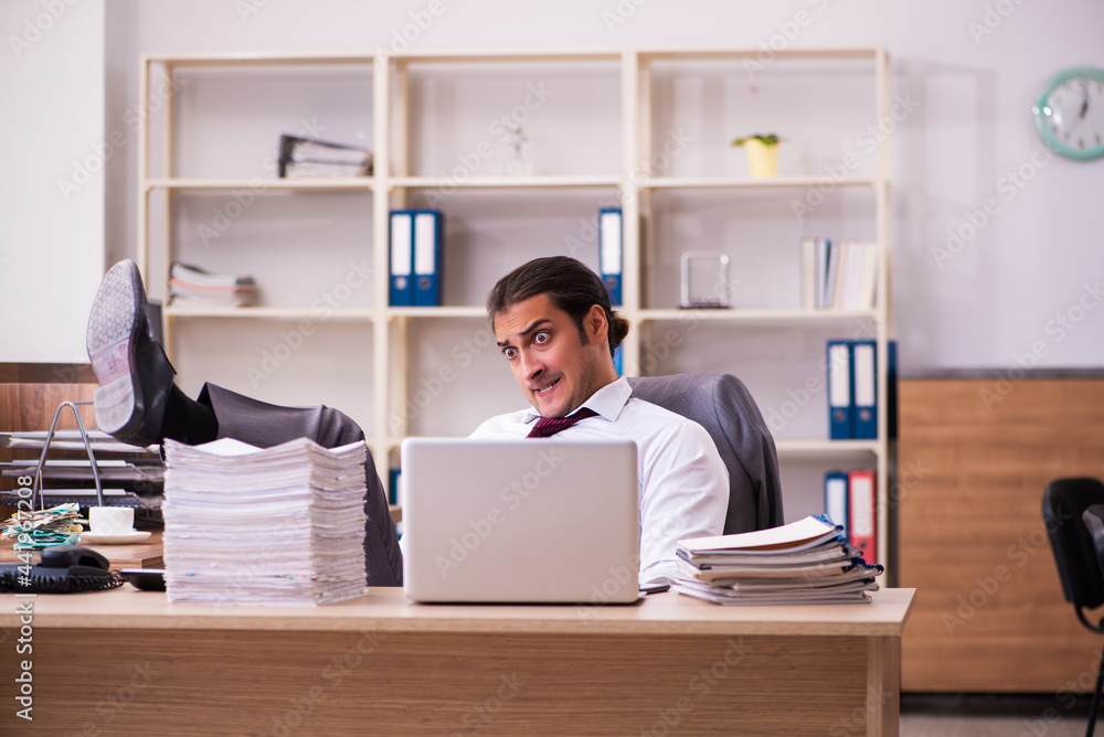 Young male employee extremely tired with excessive work Young male employee extremely tired with excessive work