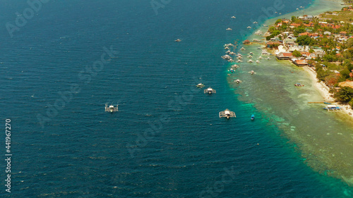 Shore with hotels near coral reef and diving boats, Moalboal, Philippines. Aerial view, Summer and travel vacation concept.