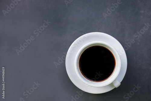 Black Crema Esspresso coffee on cup and coffee beans top view on dark background