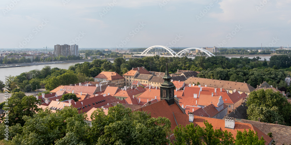 Renovated roofs of the old town below the Petrovaradin fortress and the Zezelj Bridge on the Danube River in Novi Sad, Serbia