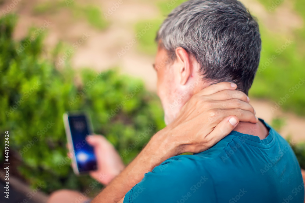 Neck pain using smartphone outdoor. Healthcare, lifestyle and technology concept Neck pain using smartphone outdoor. Healthcare, lifestyle and technology concept