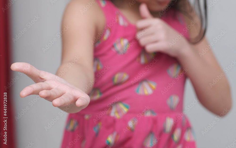 A little girl with pink shirt is giving right hand and left hand showing thumb up. No face seen. A little girl with pink shirt is giving right hand and left hand showing thumb up. No face seen.