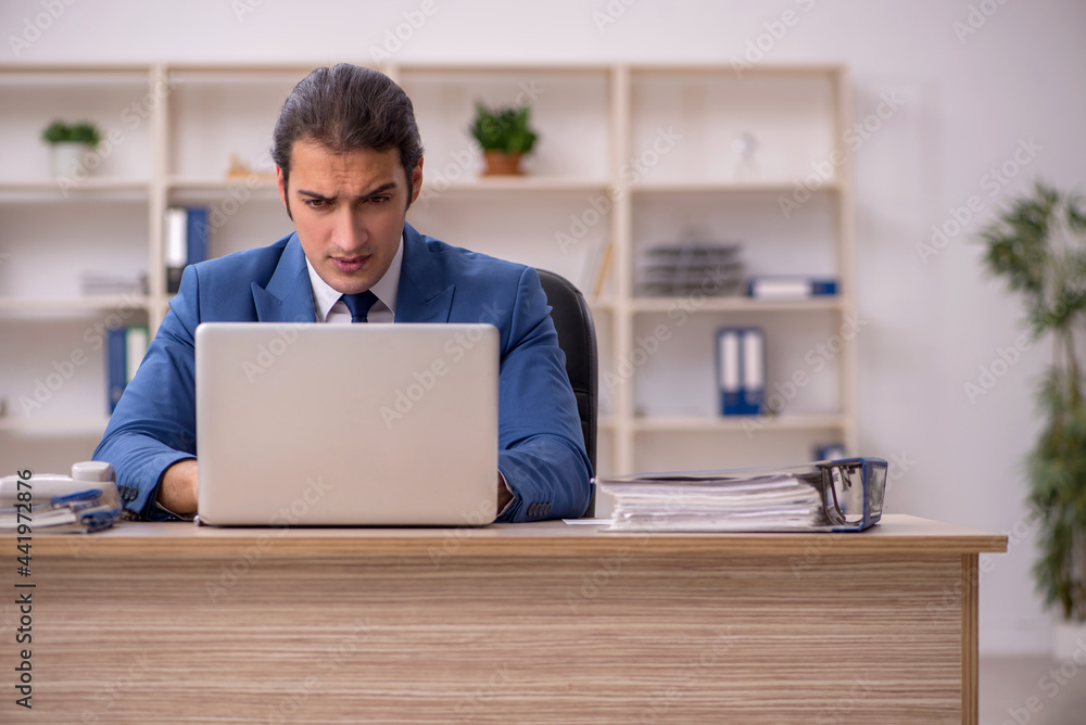 Young male employee sitting in the office Young male employee sitting in the office