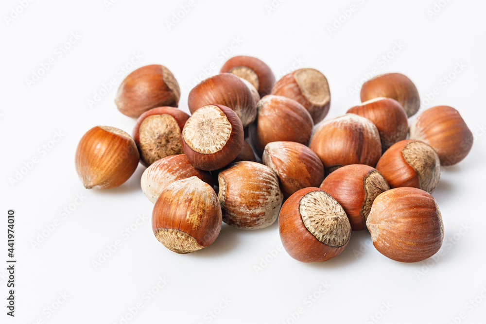 Stack of ripe hazelnuts on a white background. Filbert nuts. Wild hazelnut. Natural organic product. Copy space. Stack of ripe hazelnuts on a white background. Filbert nuts. Wild hazelnut. Natural organic product. Copy space.