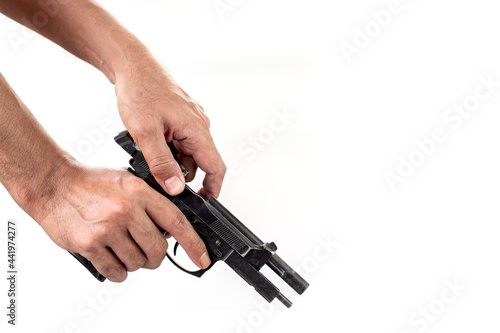 Hand holding a gun with a loaded magazine isolated on white background.