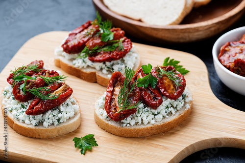 Bread slices with ricotta cheese and, sun dried tomatoes in olive oil.