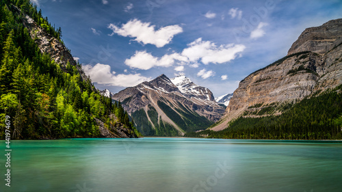 The silky looking turquoise water of Kinney Lake in Robson Provincial Park in the Canadian Rockies in British Columbia, Canada. Whitehorn Mountain and Cinnamon Peak in the background photo