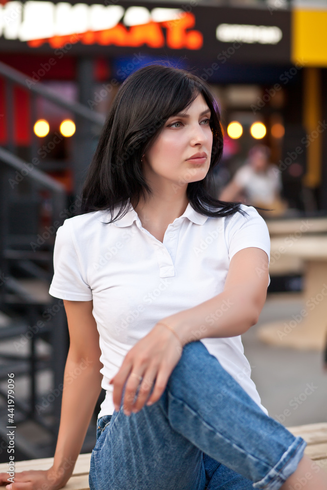 Beautiful brunette urban woman sitting near by cafe outdoor