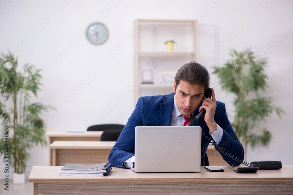 Young male employee sitting in the office Young male employee sitting in the office