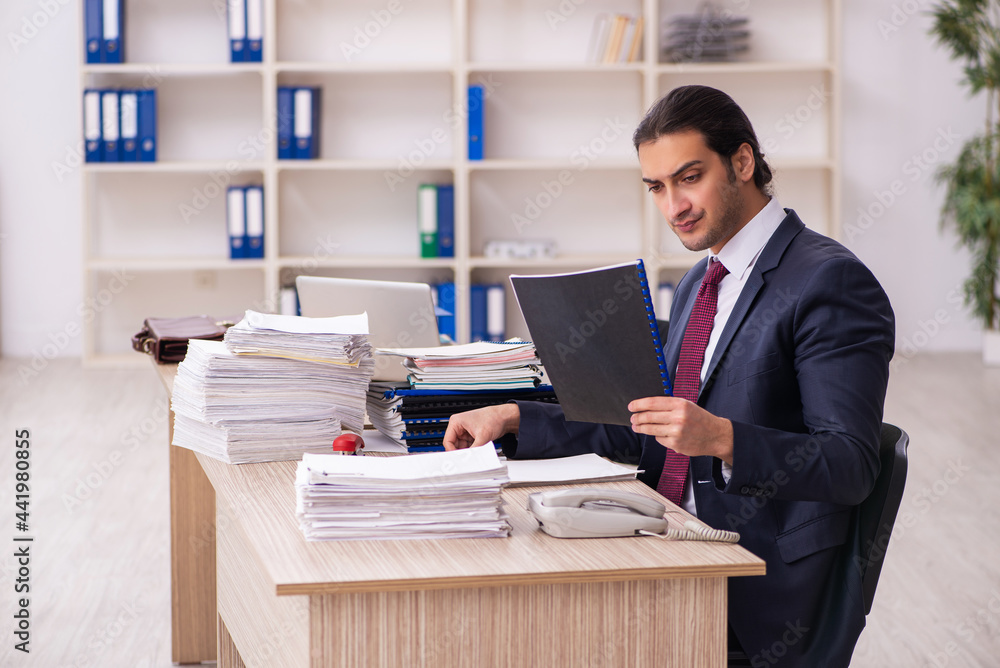 Young male employee unhappy with excessive work Young male employee unhappy with excessive work