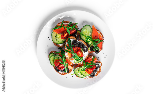 Bruschetta with cream cheese, salmon and vegetables isolated on a white background. Toasts isolated. Sandwich isolated. Sandwich with salmon and cheese.