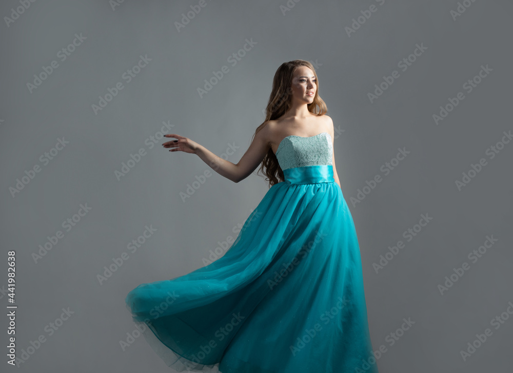 Fototapeta premium wonderful dancing princess in a lush blue dress, a young beautiful blonde