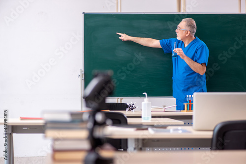 Old male teacher chemist in the classroom © Elnur