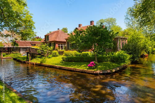 The famous village of Giethoorn in the Netherlands with traditional dutch houses, gardens and water canals and wooden bridges is know as "Venice of the North"