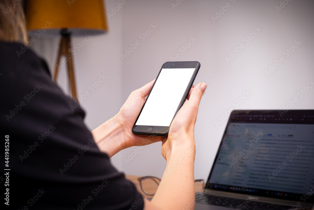woman hands holding usings smartphone at home with laptop on table, online shopping woman hands holding usings smartphone at home with laptop on table, online shopping