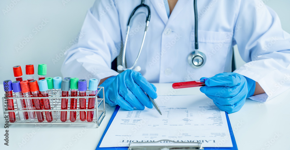 The doctor hand records the blood test examination results and medication usage of the patient on the chart, medical check-up concept The doctor hand records the blood test examination results and medication usage of the patient on the chart, medical check-up concept
