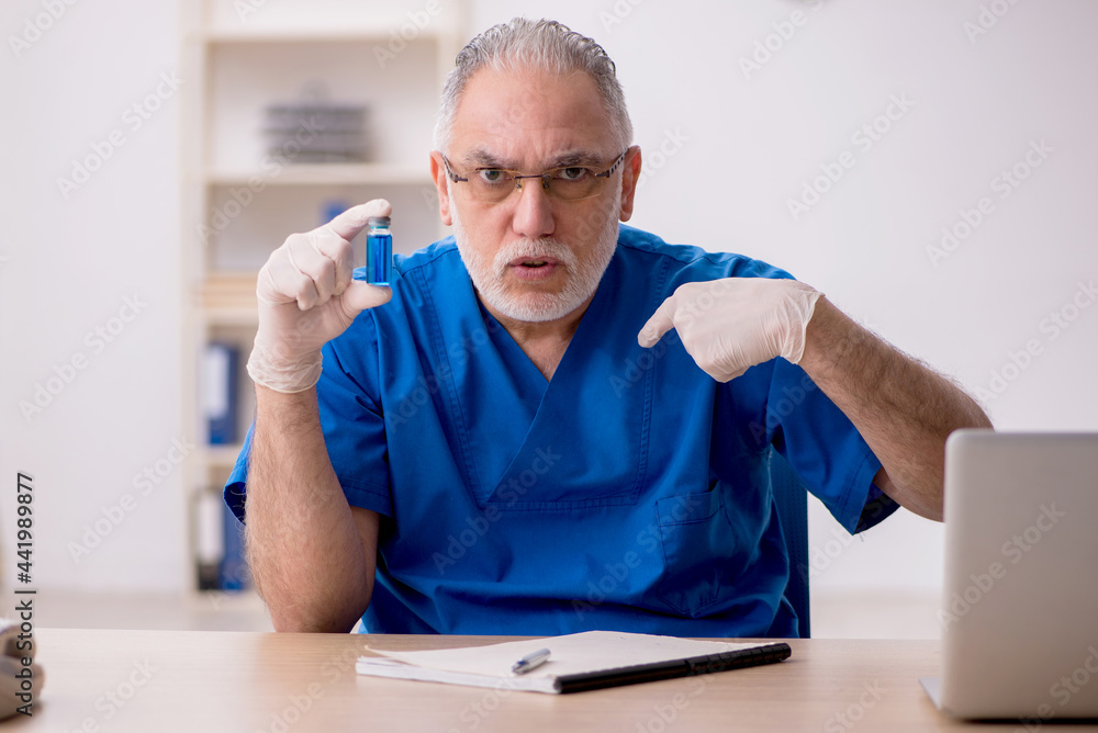 Fototapeta premium Old male doctor in vaccination concept