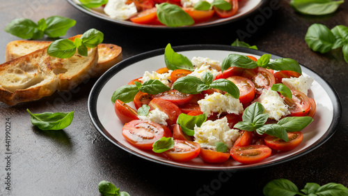 Caprese salad with cherry plum tomatoes, mozzarella cheese and basil. Healthy vegetarian food