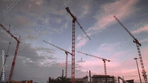 Construction site at night Time Lapse. Working tower cranes, buildings and traffic