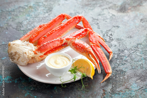 Crab legs with sauce and lemon on a plate, selective focus