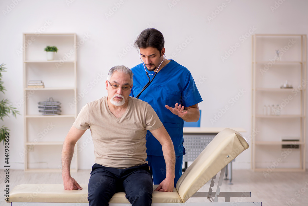 Obraz premium Old male patient visting young male doctor