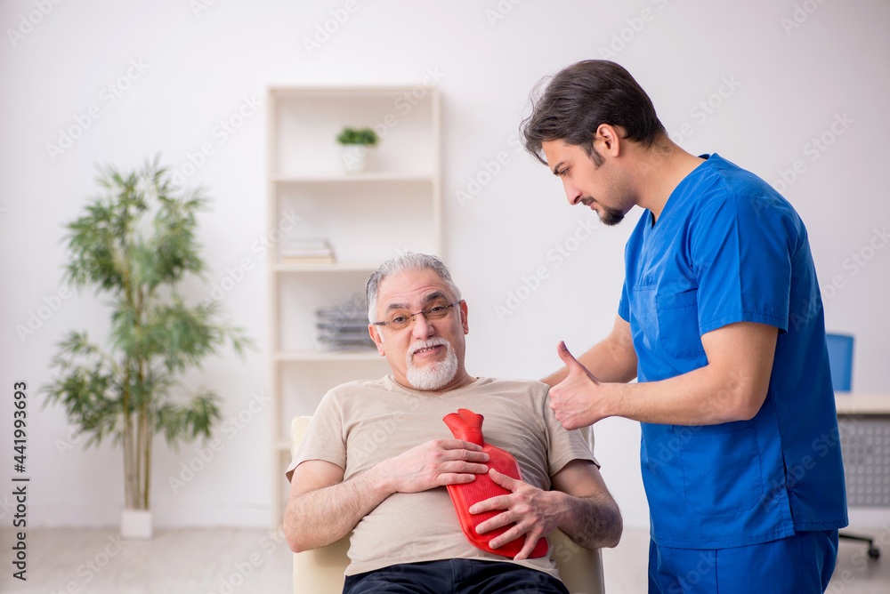 Obraz premium Old male patient visting young male doctor gastroenterologist