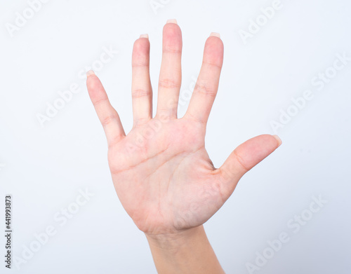 Woman's hand with pink manicure over isolated white background pointing up with fingers number five . © Roquillo