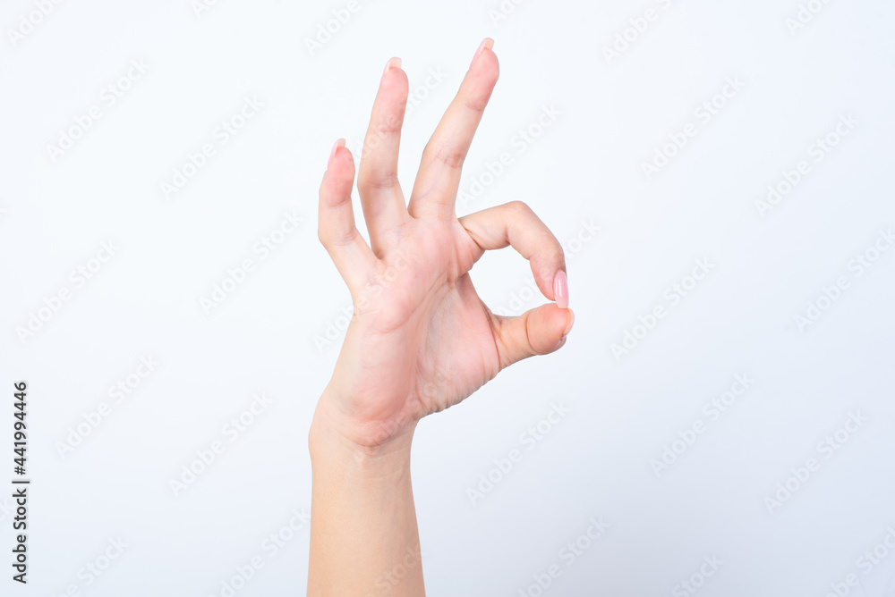 hand showing ok sign over white studio background. hand showing ok sign over white studio background.