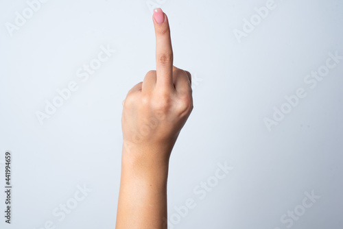 hand pointing up with middle finger  concept of rude hand sign or hand gesture  studio isolated over white background. 
