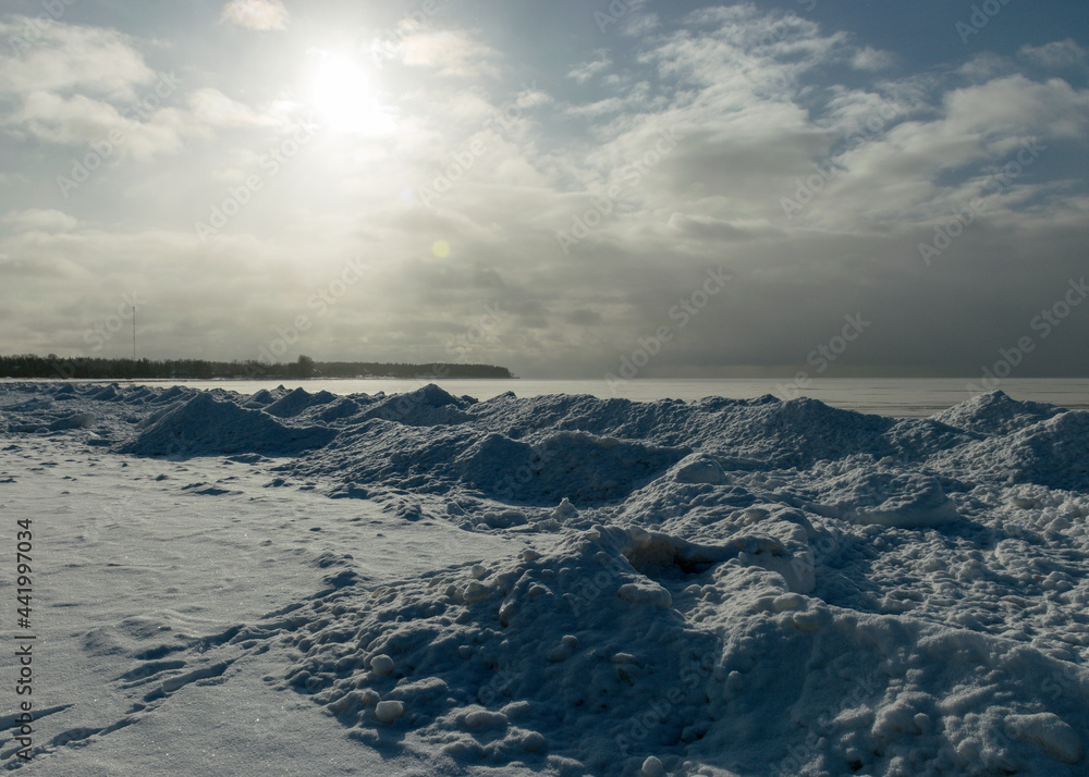 winter landscape by the sea, snowy pieces of ice by the sea, dunes covered with a white layer of shining snow