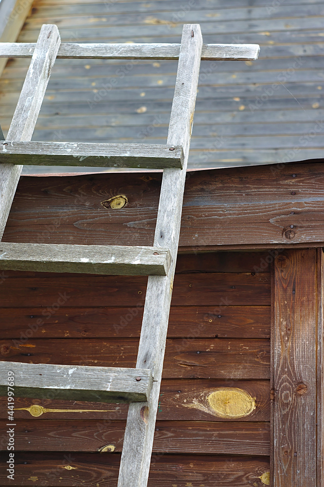 an old staircase by the wall of a wooden building