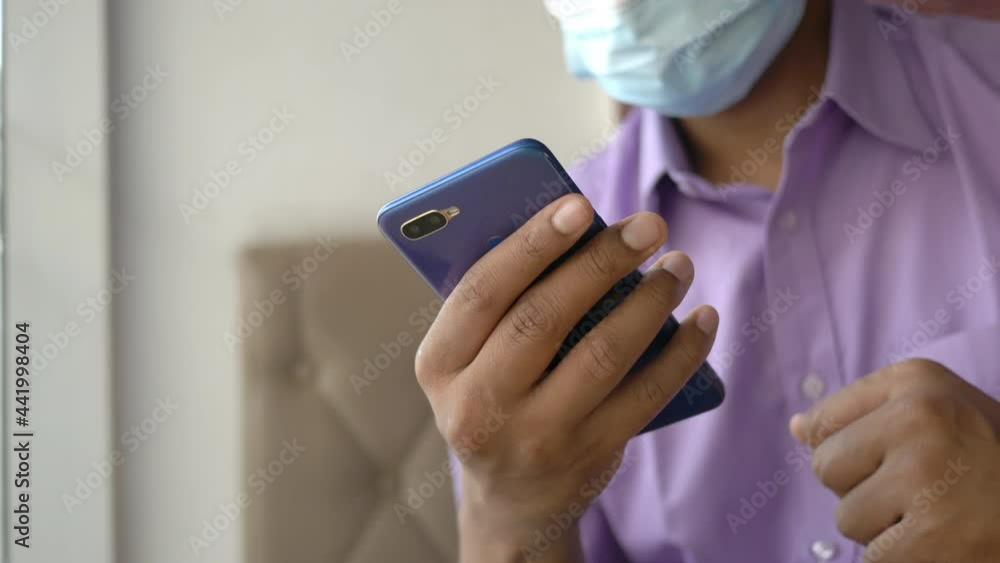 young man in face mask hand using smart phone indoor young man in face mask hand using smart phone indoor
