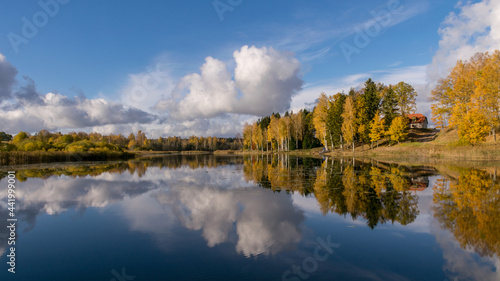 panoramic colorful landscape with beautiful clouds and trees in the lake, gorgeous trees by the pond, golden autumn