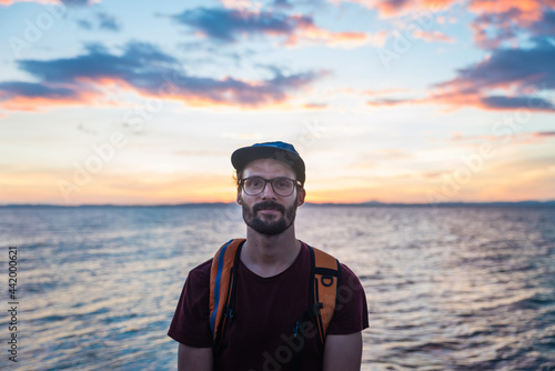 Young and inspiring traveler with a colourful background at sunset.
