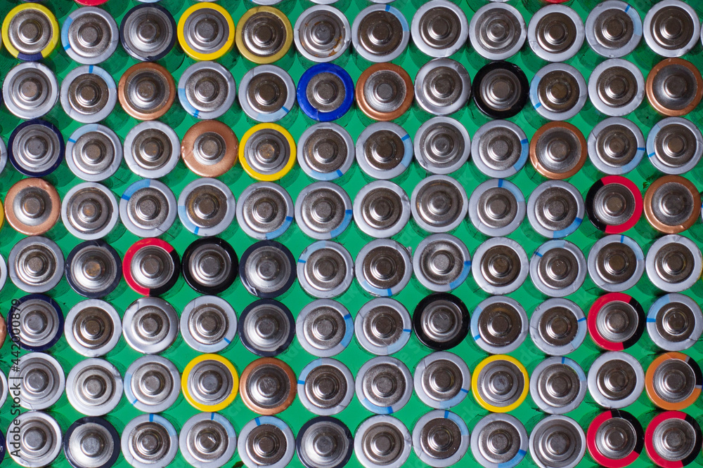 several alkaline batteries on top of each other on a green background several alkaline batteries on top of each other on a green background